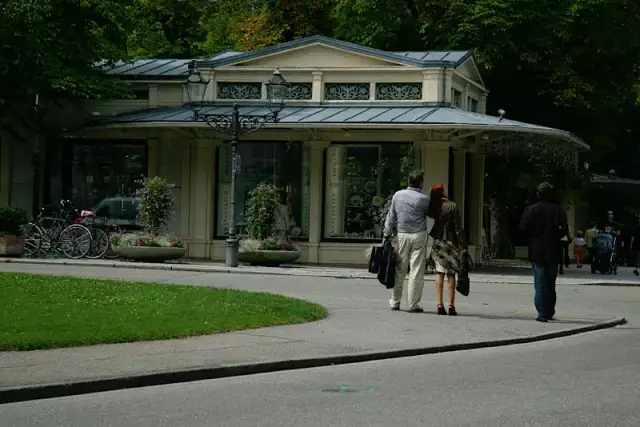 Ein junges, wohlhabendes Pärchen steht vor einem Pavillon in Baden-Baden