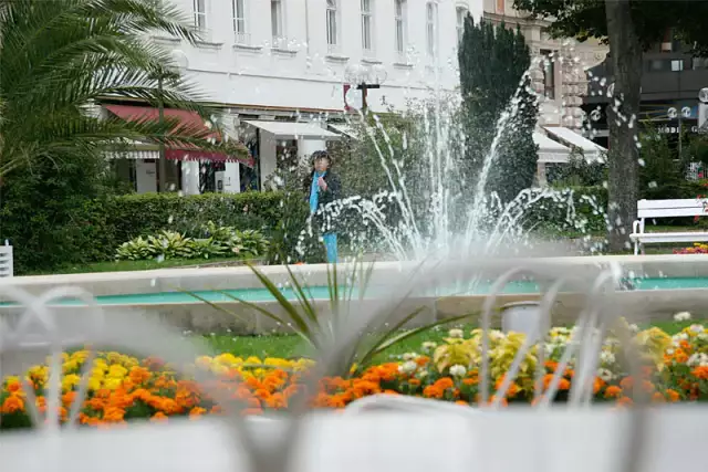 Springbrunnen in Baden-Baden, im Vordergrund ein unscharfer Gartenstuhl
